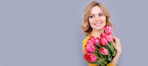 Femme positive avec des tulipes sur fond gris Bannière de portrait de visage isolé de femme avec espace de copie maquette