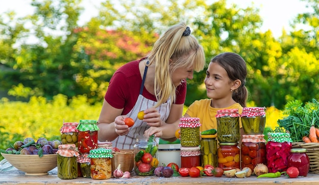 Femme avec pot de légumes conservés pour la mère et la fille d'hiver Mise au point sélective