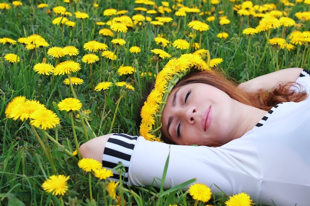 Femme sur la prairie de pissenlit au sol