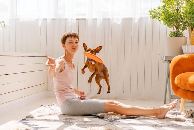 Femme pratiquant l'exercice avec un chien pour profiter et se détendre avec le yoga