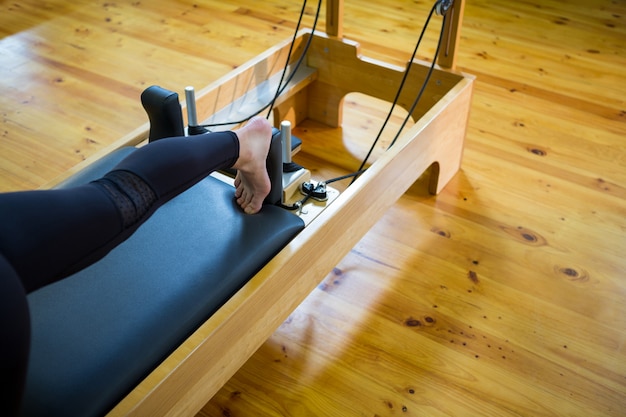 Photo femme pratiquant un exercice d'étirement sur réformateur