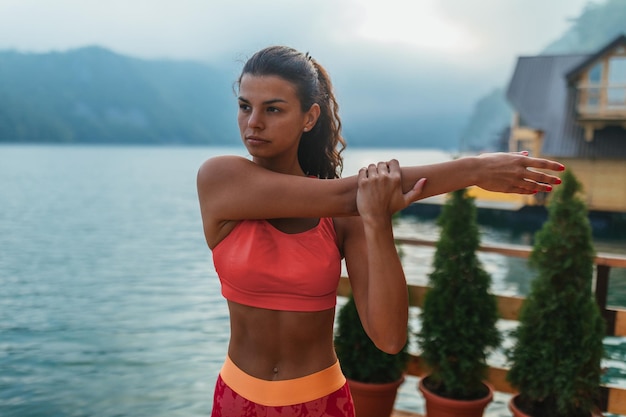 Femme pratiquant des poses de yoga dans la nature à la jetée du lac