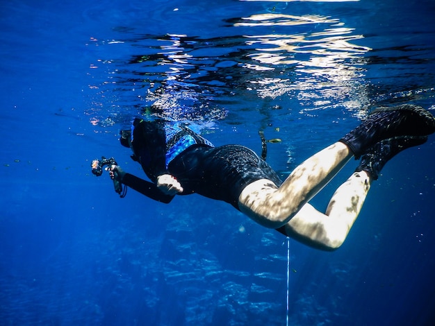 Femme pratiquant skorkel dans les eaux bleues