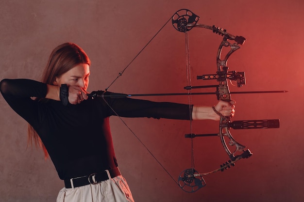 Femme pratiquant le tir à l'arc contre le mur