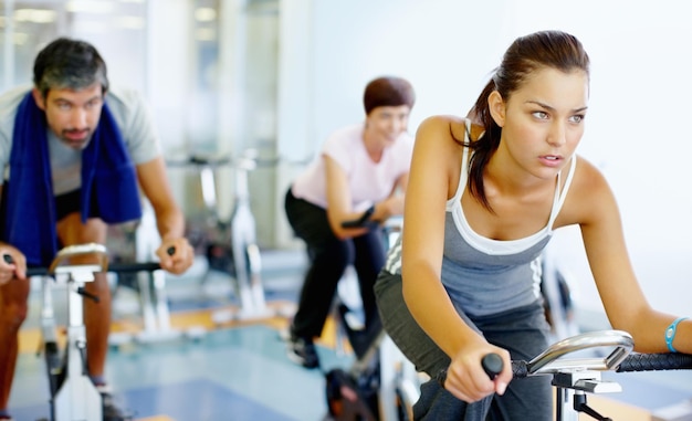 Femme pratiquant sur un vélo de vitesse à la salle de sport Belle femme travaillant sur un vélo stationnaire à la salle de sport