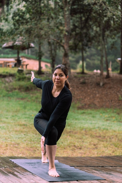 Femme pratiquant le yoga dans une forêt portant des vêtements de sport. Le bien-être.