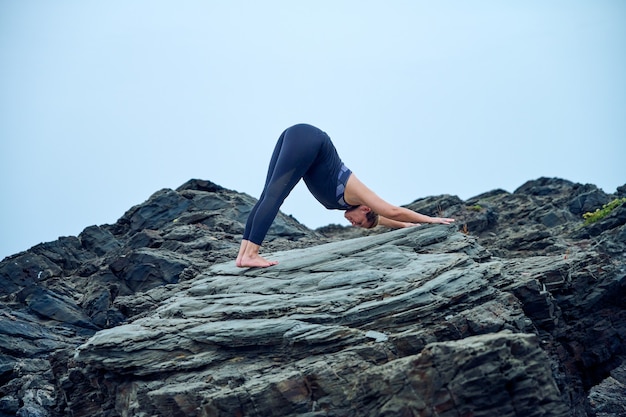 femme pratiquant le yoga devant la mer