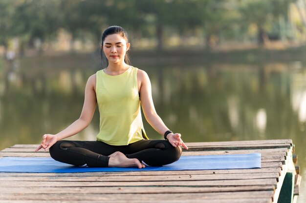 Femme pratiquant le yoga faisant du yoga dans le parc du matin