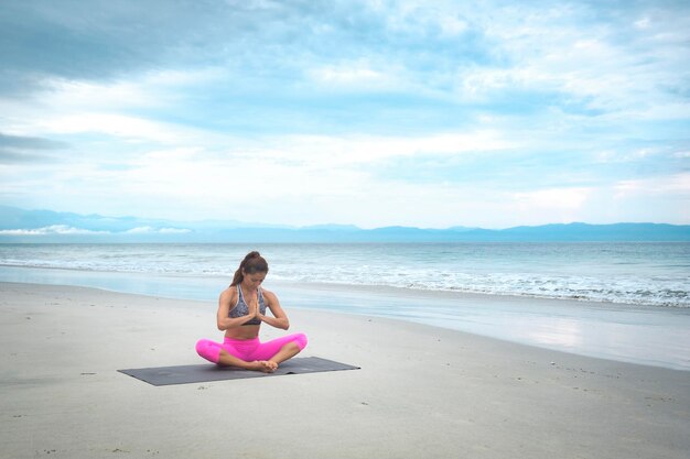 Femme pratiquant le yoga sur la plage