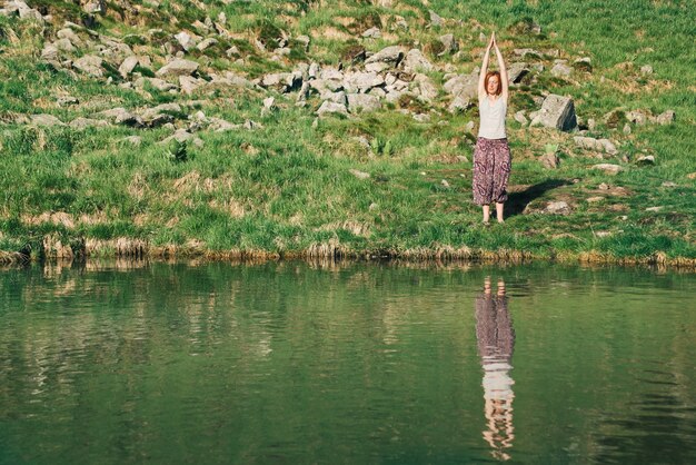 Une Femme Pratique Le Yoga Devant Le Lac De Montagne