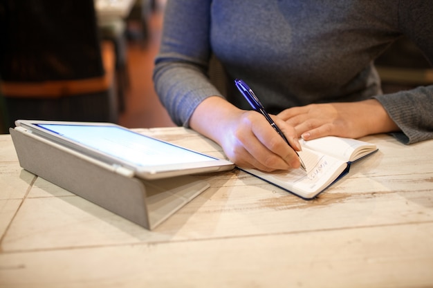 Femme prenant des informations dans un cahier