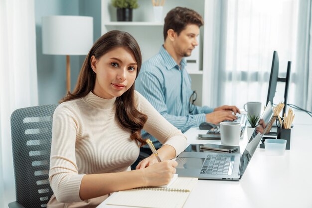 Femme prenant note cruciale sur la paperasserie pour regarder le postulat de la caméra