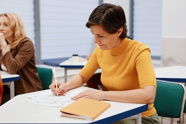 Femme prenant des notes au bureau lors d'une conférence