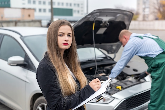 Femme prenant des notes pendant qu'un travailleur fait un diagnostic