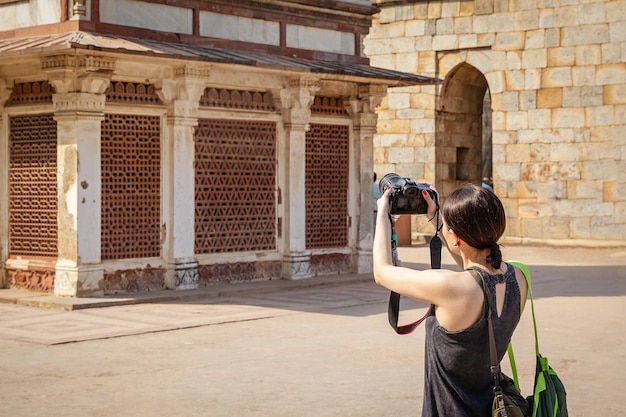 Une femme prenant une photo d'un bâtiment en Inde