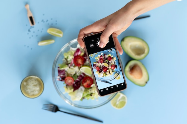 Photo femme prenant une photo d'un bol de salade