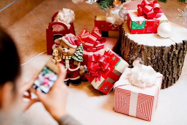 Femme prenant une photo de cadeaux de Noël.