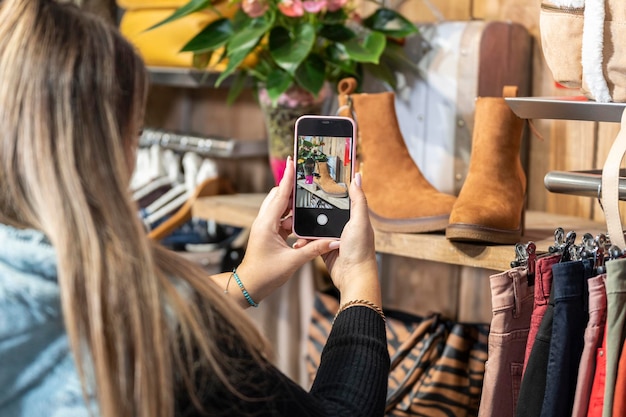 Photo femme prenant une photo de chaussures dans un magasin de vêtements