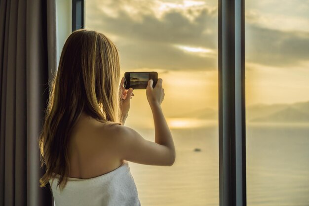 Femme prenant une photo de la ville à la lumière du matin