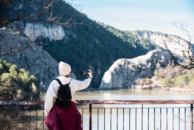 Femme prenant des photos avec un téléphone portable dans la nature