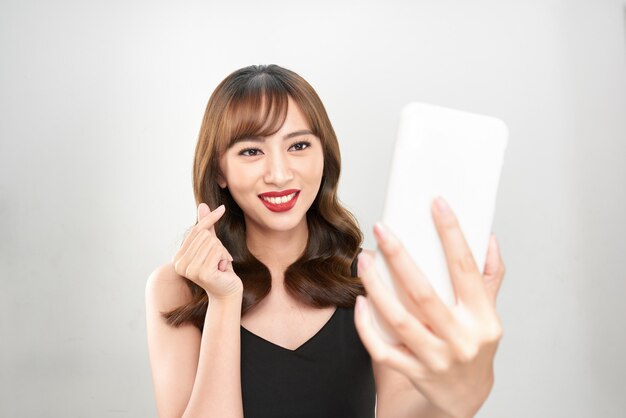 Femme prenant selfie avec coeur de style coréen