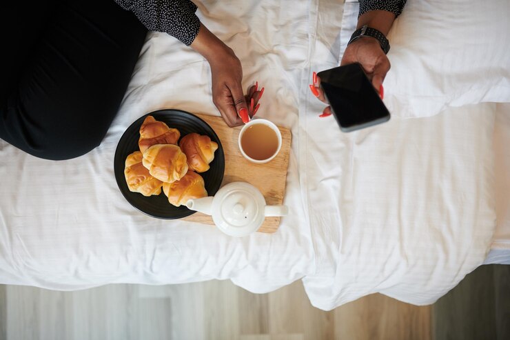 Femme prenant le thé avec des croissants