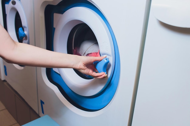 Photo femme prenant des vêtements de couleur de la machine à laver