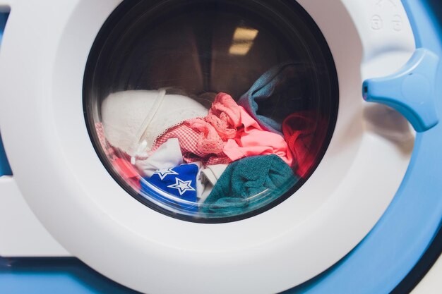 femme prenant des vêtements de couleur de la machine à laver