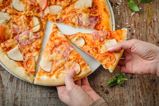 Femme prend deux tranches de pizza