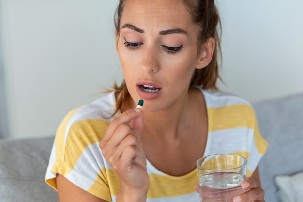 La femme prend des médicaments avec un verre d'eau norme quotidienne de vitamines médicaments efficaces pharmacie moderne pour le corps et le concept de santé mentale