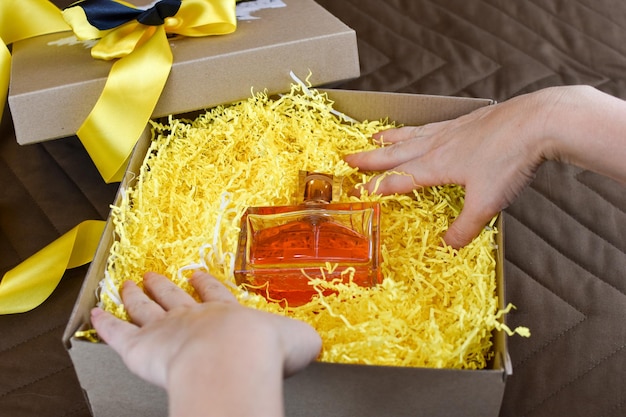 La femme prend le parfum parfumé d'une boîte-cadeau. beau cadeau pour une femme