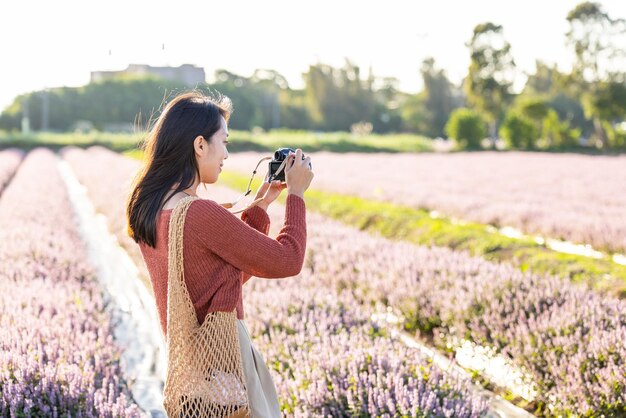 Photo une femme prend une photo à la caméra dans un champ de fleurs de mesona chinoise dans le district de taoyuan yangmei