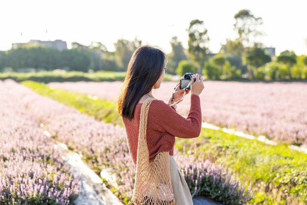 Une femme prend une photo du champ de fleurs.