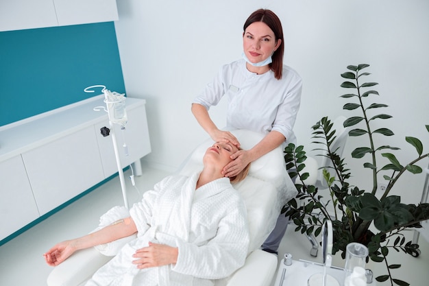 La femme prend soin de sa peau et fait des procédures de cosmétologie et de laser