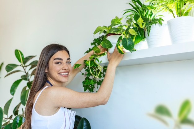 La femme prend soin de ses plantes à la maison