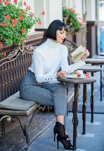 Une femme prend un verre et profite d'un bon livre sur la terrasse d'un café Concept d'auto-amélioration Littérature pour femme