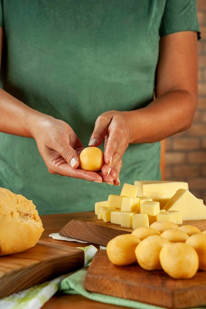 Photo femme préparant une croquette farcie au fromage brésilien bolinha de queijo sur une table en bois