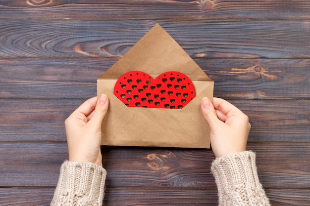 Femme préparant une enveloppe à la main pour emballer le jour de la Saint-Valentin. Concept de la Saint-Valentin