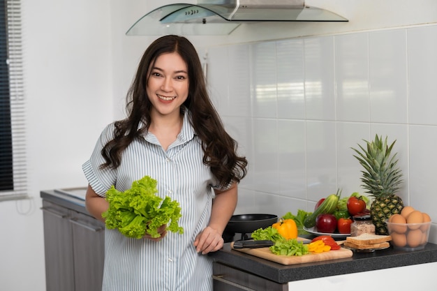 Femme préparant des légumes pour cuisiner dans la cuisine à la maison