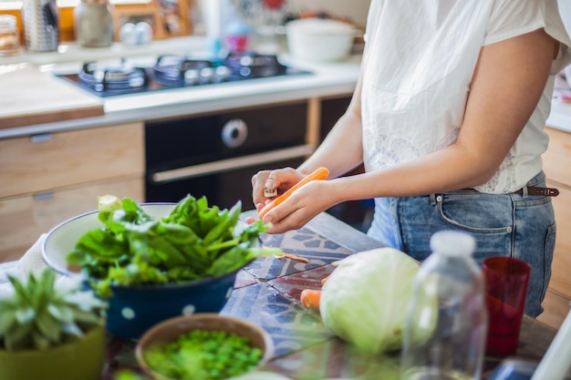 Femme préparant de la nourriture sur une planche à découper à la maison