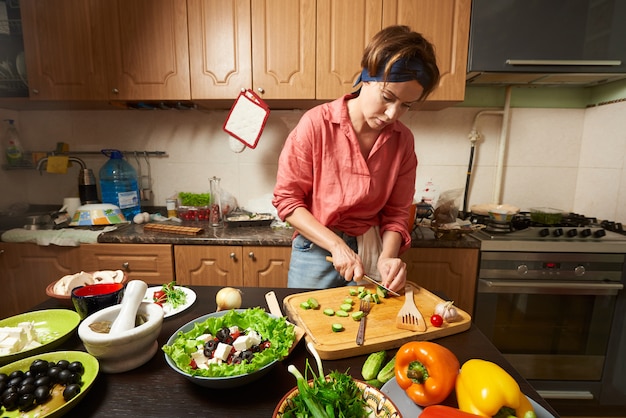 Femme préparant une salade saine dans la cuisine