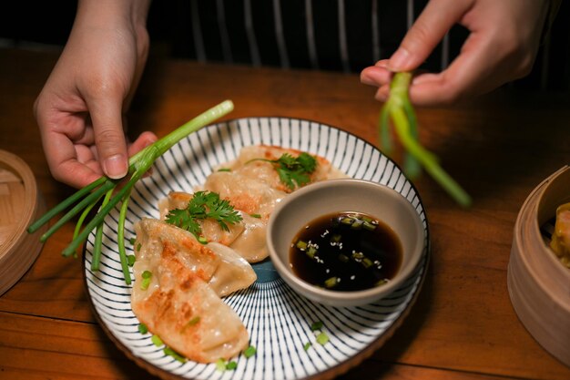 Femme préparant ses boulettes frites chinoises spéciales dans la cuisine Gyoza dim sum cuisine asiatique