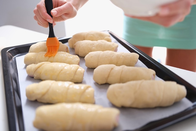 Femme prépare des croissants et badigeonner la pâte de jaune d'oeuf