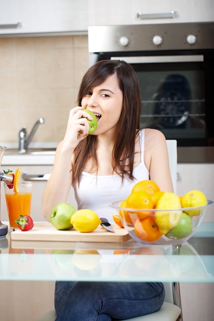 Femme prépare un jus de fruit avec un presse-agrumes