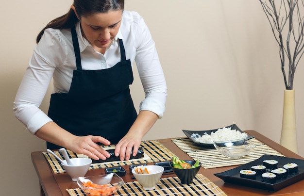 Une femme prépare la nourriture sur la table.