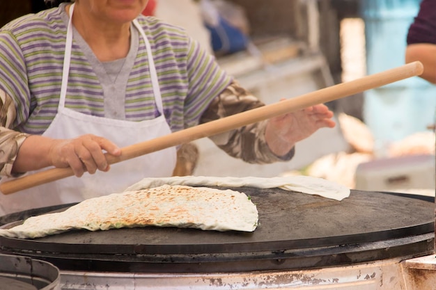 Une femme prépare des pâtisseries turques traditionnelles gozleme