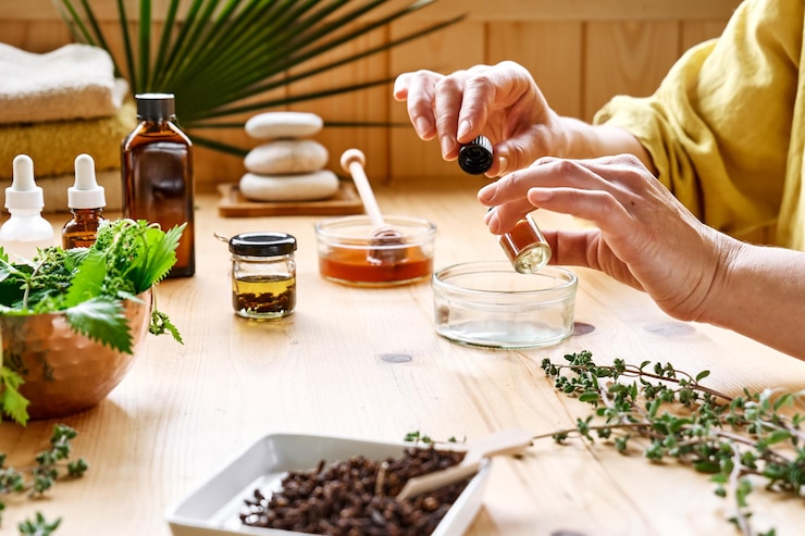 Photo une femme prépare une séance d'aromathérapie avec un diffuseur d'huiles essentielles, des herbes médicinales, des huiles et des essences.