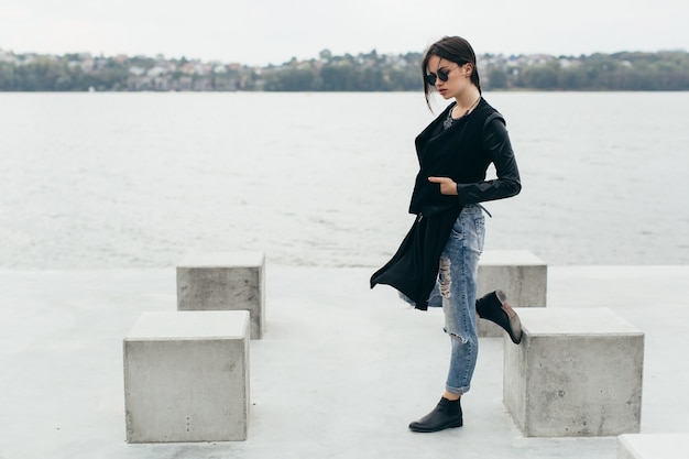 Femme près des cubes de ciment et de la rivière