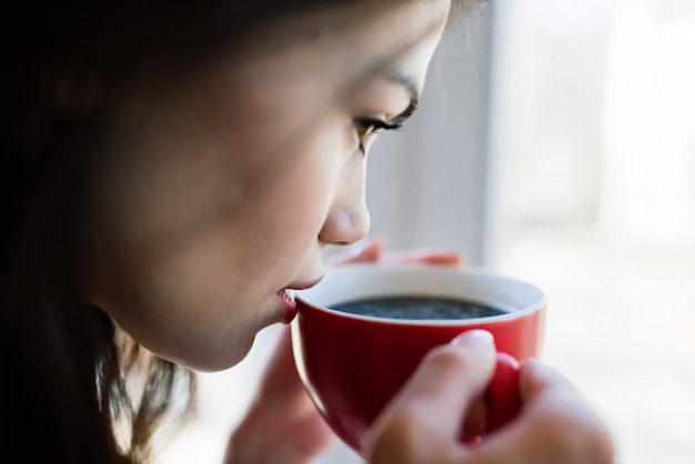 Femme près de la fenêtre à la maison. Rêve et détente