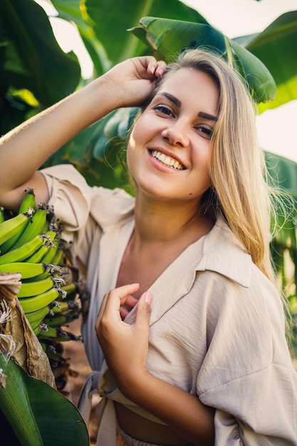 Femme près d'une grande feuille verte de bananier sur la nature dans le parc Plantes tropicales